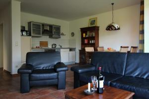 a living room with a couch and a table with a bottle of wine at Strandlöper in Wustrow