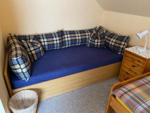 Bett mit karierten Kissen auf einem Zimmer in der Unterkunft Kreutzmann Ferienwohnung für einen erholsamen Urlaub in ruhiger, zentraler Lage in Heiligenhafen