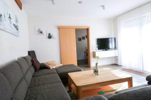 sala de estar con sofá y mesa de centro en Familienhof Brüning - Terrassenwohnung, en Meppen