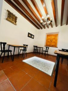 una sala da pranzo con tavoli, sedie e soffitto di Albergue Hospedería Montaña Morciguillinas a Cortijos Nuevos