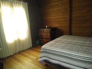 a bedroom with a bed and a dresser and a window at Casa de campo Rosa dos ventos in Rodeio +44 photos