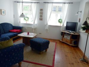 sala de estar con sofá azul y TV en Eichenpark 52, en Prerow