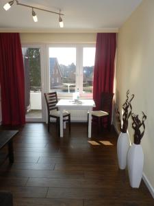 a dining room with a white table and red curtains at MPH - Whg 15 in Wyk auf Föhr