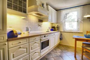 a kitchen with white cabinets and a sink and a window at Tabbert, Kerstin in Zingst