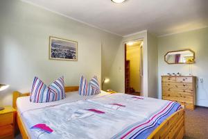 a bedroom with a large bed with blue sheets and a dresser at Tabbert, Kerstin in Zingst