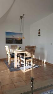 uma sala de jantar com uma mesa branca e cadeiras em Parkresidenz am Hafen 15 em Zingst