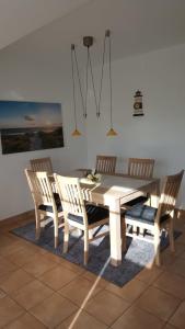 uma mesa de jantar com 4 cadeiras e uma mesa e uma mesa e uma espreguiçadeira em Parkresidenz am Hafen 15 em Zingst