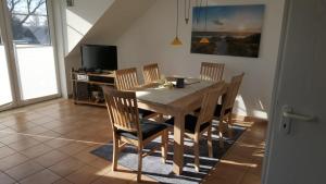 uma sala de jantar com uma mesa de madeira e cadeiras em Parkresidenz am Hafen 15 em Zingst