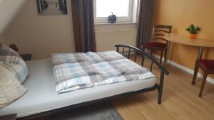 Zimmer mit einem Bett, einem Tisch und einem Fenster in der Unterkunft Ferienwohnung Vetter in Loose
