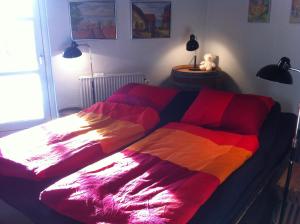 霍森斯的住宿－Bed & Breakfast Horsens - Udsigten，一张床上有五颜六色的毯子,放在房间里