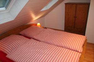 a bed with an orange and white striped sheets in a room at Ferienhaus Maria Magdalena in Bad Lauterberg