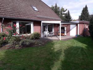 a house with a patio with a table and chairs at Haus Tuti-No3 in zentraler Lage und doch im Grünen in Soltau