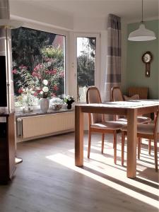 a dining room with a table and chairs and a window at Haus Tuti-No3 in zentraler Lage und doch im Grünen in Soltau