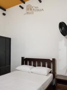 a bedroom with a bed with white sheets at Hotel Boutique Casa Antigua in San Vicente de Chucurí