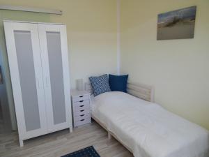 ein kleines Schlafzimmer mit einem Bett und einem Schrank in der Unterkunft Muschelkoje in Stakendorfer Strand