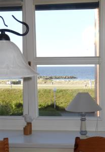 ein Fenster mit Blick auf den Strand in der Unterkunft Muschelkoje in Stakendorfer Strand