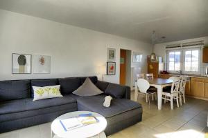 a living room with a blue couch and a table at Am Deich 14 in Zingst