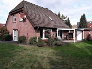 a red brick house with a patio in the yard at Haus Tuti-No3 in zentraler Lage und doch im Grünen in Soltau