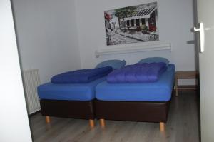 a blue ottoman with two blue pillows on it at Dune Park Bungalow Stuga, Sauna, BBQ, Netflix in De Cocksdorp