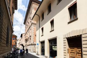 a group of people walking down a street next to a building at Goito 3, Bologna by Short Holidays in Bologna