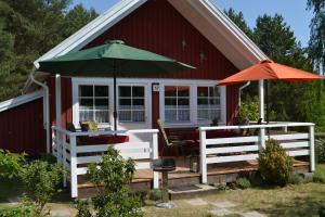 un cottage rosso con tavolo e ombrellone di Haus Vogelsang a Userin