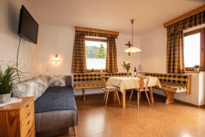 - un salon avec un canapé et une table à manger dans l'établissement Christof,s Ferienwohnung WILD230, à Oberau