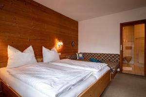 a bedroom with a large bed with a wooden wall at Christof,s Ferienwohnung WILD230 in Oberau