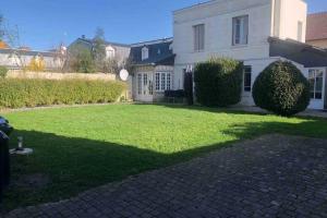 a house with a large lawn in front of it at Spacieuse villa avec jardin Deauville centre in Deauville