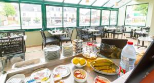 a restaurant with a counter with bananas and other food at Logis Hôtel & Restaurant - Le Saint-Louis in La Suze-sur-Sarthe