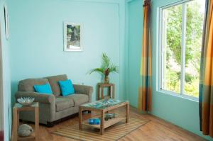 a living room with a couch and a table at Diamond View Cottages in Roseau