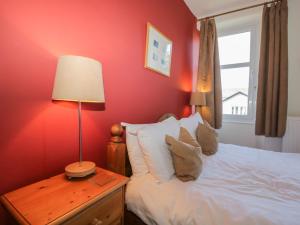 a bedroom with a bed and a lamp on a table at Gillercombe in Bowness-on-Windermere