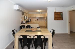 a dining room and kitchen with a wooden table and chairs at Tanunda's Magpie House in Tanunda