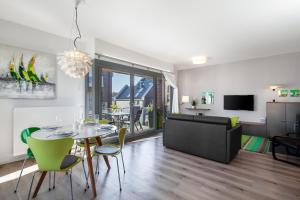 ein Wohnzimmer mit einem Tisch, Stühlen und einem Sofa in der Unterkunft Ostsee - Appartement Nr 61 "Seebrise" im Strand Resort in Heiligenhafen