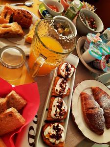 a table topped with plates of pastries and a glass of orange juice at Room Inn in Milan