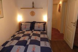 a bedroom with a bed with a blue and white quilt at Sonnenhus Zingst in Zingst