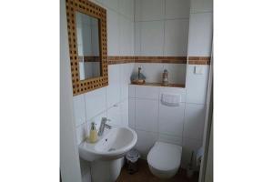 a white bathroom with a sink and a toilet at Sonnenhus Zingst in Zingst
