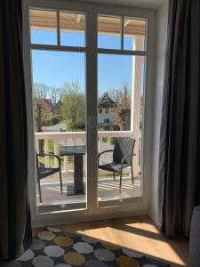 a sliding glass door with a table and chairs on a balcony at Villa Balticum, Whg 4 in Zingst