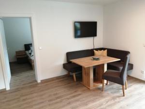 una habitación con una mesa y una silla y un televisor en Apartment Hirz, en Gröbming