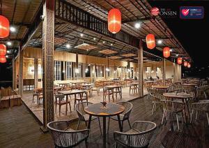 an empty restaurant with tables and chairs and lights at The Onsen Hot Spring Resort in Batu