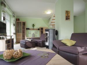 uma sala de estar com sofás roxos e uma televisão em Grüner Winkel 32a em Zingst