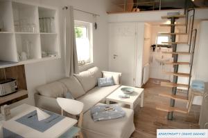 sala de estar con sofá y escalera de caracol en Tolles Studio Apartment in Tossens für junge Paare, en Tossens