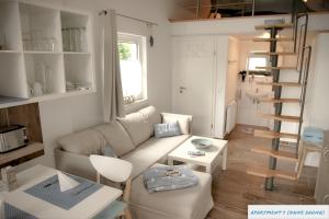a living room with a couch and a spiral staircase at Tolles Studio Apartment in Tossens für junge Paare in Butjadingen OT Tossens