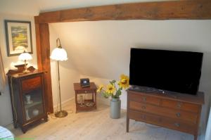 a living room with a flat screen tv on a dresser at Haus 94-Whg OG in Oldsum