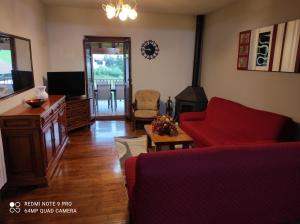 a living room with a red couch and a tv at Casa Rural Juankonogoia in Urrotz