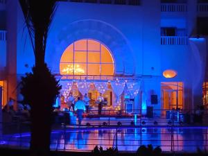 un gruppo di persone di notte di fronte a un edificio di Medina Solaria And Thalasso a Hammamet