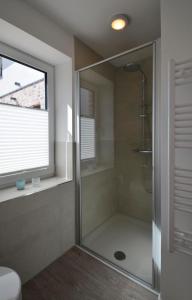 a shower with a glass door in a bathroom at Skagen in Kronsgaard