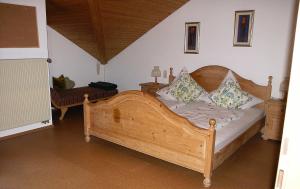 a bedroom with a wooden bed with pillows on it at Ferienwohnung Nr 3, Lechbruck-Prem, Allgäu in Prem