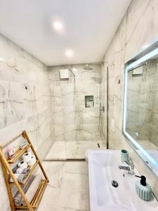 a bathroom with a white sink and a shower at Central Studio Apartment 1, Tirana in Tirana