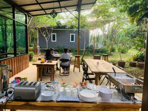 a patio with a table and people sitting at tables at Sonseesaed Farm at Phurua in Phu Ruea