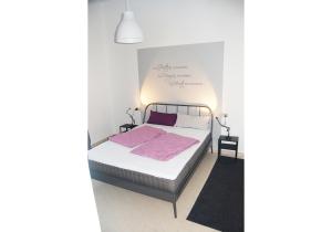 1 dormitorio blanco con 1 cama con sábanas rosas en da Marianna, en Perticara